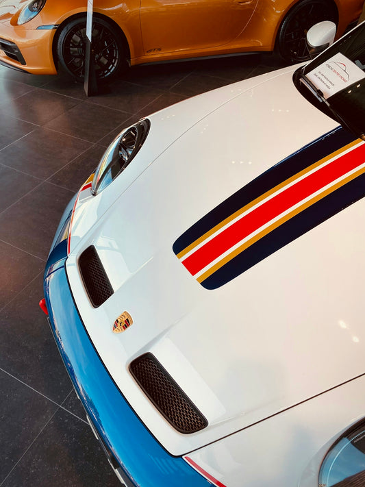 two sports cars parked next to each other in a garage