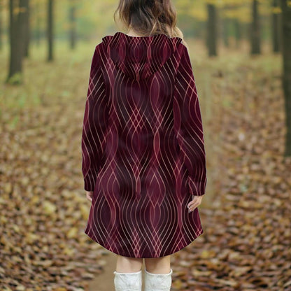 Person wearing a patterned dress standing in an autumn forest.